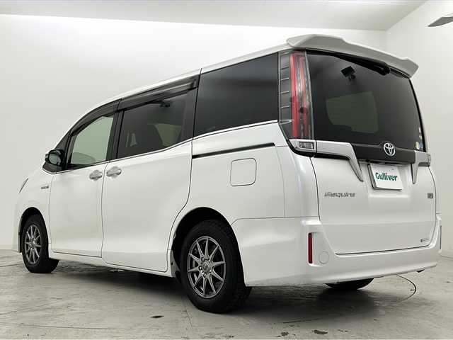 トヨタ エスクァイア ハイブリッド Gi プレミアムパッケージ 宮城県 2017(平29)年 11.8万km ホワイトパールクリスタルシャイン 禁煙車/フリップダウンモニター/トヨタセーフティセンス/・プリクラッシュセーフティ/・レーンディパーチャーアラート/・オートマチックハイビーム/・レーダークルーズコントロール/純正9インチSDナビ/・BT/AM/FM/CD/SD/フルセグTV /バックカメラ/両側パワースライドドア/前席シートヒーター/ビルトインETC/革巻きステアリング/ステアリングヒーター/プッシュスタート/スマートキー×2/LEDヘッドライト/LEDフォグランプ/社外15インチアルミホイール/積み込み純正アルミホイール付き夏タイヤ/（195/65R15）/純正フロアマット/純正ドアバイザー