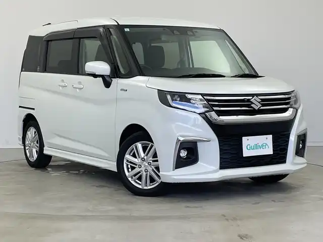 スズキ ソリオ HV MZ 新潟県 2021(令3)年 6万km ピュアホワイトP 純正メモリナビ/（BT/FM/AM/フルセグTV/DVD)/全周囲カメラ/衝突軽減ブレーキ/レーダークルーズコントロール/ステアリングスイッチ/シートヒーター/両側パワースライド/ヘッドアップディスプレイ/純正15インチアルミホイール/純正フロアマット/純正オートヘッドライト/電格ミラー/サンシェード/ETC