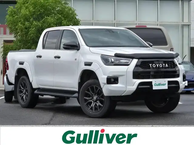 トヨタ ハイラックス Z GRスポーツ 鹿児島県 2023(令5)年 2.4万km スーパーホワイトⅡ レーダークルーズコントロール　/ＥＴＣ　/純正メモリーナビ　/アラウンドビューモニター　/Ｂｌｕｅｔｏｏｔｈオーディオ　/Ｄ席パワーシート　/ＥＧＲ製バグガード　/トラクションコントロール　/パワーヒート/レーンディパーチャーアラート/プリクラッシュセーフティシステム/排出ガス浄化スイッチ/GR純正アルミホイール(18インチ)/前後コーナーセンサー/プッシュスタート/スマートキー/横滑り防止装置/レーンキープアシスト/ディーゼルターボ車/エアバッグ(Ｗ＋サイド)