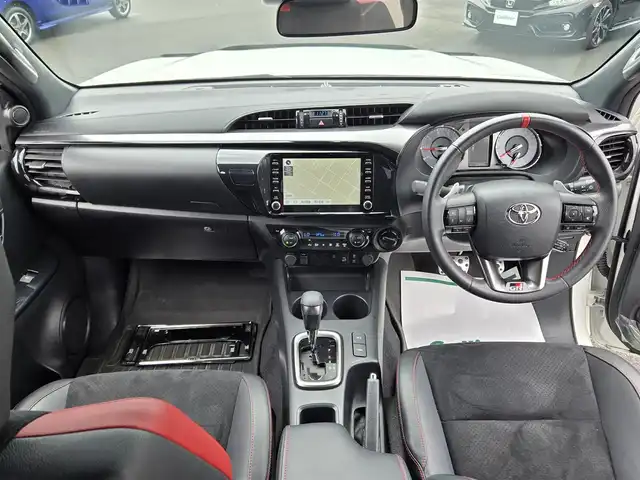トヨタ ハイラックス Z GRスポーツ 鹿児島県 2023(令5)年 2.4万km スーパーホワイトⅡ レーダークルーズコントロール　/ＥＴＣ　/純正メモリーナビ　/アラウンドビューモニター　/Ｂｌｕｅｔｏｏｔｈオーディオ　/Ｄ席パワーシート　/ＥＧＲ製バグガード　/トラクションコントロール　/パワーヒート/レーンディパーチャーアラート/プリクラッシュセーフティシステム/排出ガス浄化スイッチ/GR純正アルミホイール(18インチ)/前後コーナーセンサー/プッシュスタート/スマートキー/横滑り防止装置/レーンキープアシスト/ディーゼルターボ車/エアバッグ(Ｗ＋サイド)