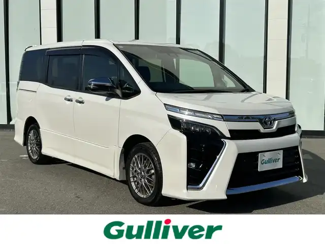 トヨタ ヴォクシー ハイブリッド ZS 煌Ⅱ 大阪府 2020(令2)年 6.3万km ホワイトパールクリスタルシャイン 純正１０インチナビ　/   フルセグＴＶ/CD/DVD/Bluetooth/USB　/バックモニター　/衝突軽減ブレーキ/リアコーナーセンサー/パーキングアシスト　/前席シートヒーター　/両側パワースライドドア/クルーズコントロール/レーンキープアシスト　/アイドリングストップ/オートマチックハイビーム　/前方ドライブレコーダー/純正16インチアルミホイール/プッシュスタート　/純正フロアマット/スマートキー　/ＥＴＣ　/ＬＥＤ