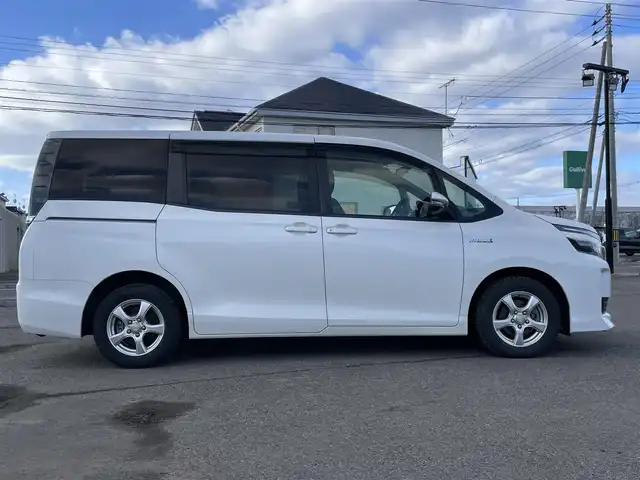 トヨタ ヴォクシー ハイブリッド X 道央・札幌 2014(平26)年 8.4万km ホワイトパールクリスタルシャイン ワンオーナー/純正ディーラーOPナビ/CD/DVD/BT/フルセグ/寒冷地仕様/純正フリップダウンモニター/横滑り防止装置/バックカメラ/ビルトインETC/EVMODE/ECOMODE/PWRMODE/片側パワースライドドア/ワイパーデアイサー/ステアリングリモコン/プッシュスタート/スマートキー/LEDヘッドライト/オートライト/電動格納ミラー/ウィンカーミラー/ドアバイザー/スペアキー/純正リモートスタート/純正AW付夏タイヤ積込/195/65/R15/2020年/4mm