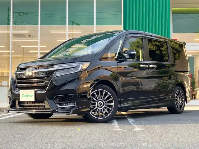 ホンダ ステップワゴン スパーダ ハイブリッドG EX HセンシングBスタイ 静岡県 2019(令1)年 5.8万km プレミアムスパークルブラックパール エンジンスタートボタン/パワーステアリング/パワーウィンドウ/100V充電/アイドリングストップ/スマートキー/Wオートエアコン/クルーズコントロール（追従有）/フリップダウンモニター/USB入力端子/ETC/バックカメラ/純正9インチメモリナビ（CD/BT/フルセグ）/三列シート/ウォークスルー/無限フロアマット/無限17インチアルミホイール/ハーフレザーシート/D席N席シートヒーター/両側パワースライドドア/フロント/サイドエアロ/ABS/横滑り防止装置/レーンキープアシスト/オートライト/LEDヘッドライト/W+サイドエアバック/カーテンエアバック/衝突軽減システム