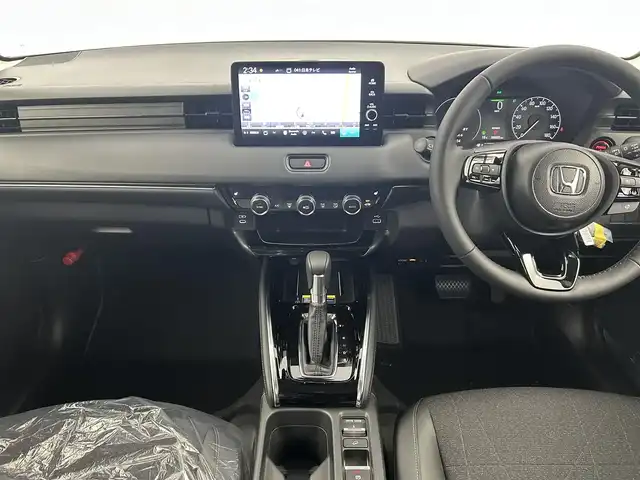 ホンダ ヴェゼル ハイブリッド e:HEV Z 千葉県 2025(令7)年 0.1千km プラチナホワイトパール 登録済未使用車/ホンダセンシング/・路外逸脱抑制機能/・標識認識機能/・車線維持支援システム/・ブラインドスポットインフォメーション/・誤発進抑制機能/・急アクセル抑制機能/・パーキングセンサーシステム/・レーダークルーズコントロール/パワーバックドア/純正９インチディスプレイオーディオ/・USB/Bluetooth/Apple CarPlay/Android Auto/フルセグTV/・バックカメラ/・ビルトインETC２.０/・置くだけ充電/革巻きステアリング/・ステアリングスイッチ/・ステアリングヒーター/・パドルシフト/ハーフレザーシート/・DNシートヒーター/左右独立エアコン/電子パーキング/・ブレーキホールド/純正１８インチAW/オートライト/・LEDヘッドライト/・LEDフォグランプ