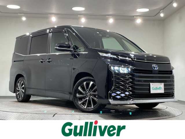 トヨタ ヴォクシー ハイブリッド S－Z 愛知県 2023(令5)年 3.8万km グリッターブラックガラスフレーク 純正10.5インチディスプレイオーディオプラス/純正フリップダウンモニター/電動サイドステップ/衝突軽減ブレーキ/両側電動スライドドア/レーダークルーズコントロール/100V電源/ビルトインETC2.0/シートヒーター/LEDヘッドライト/バックカメラ/フルセグTV/Bluetooth/コーナーセンサー/レーンキープアシスト/オートハイビーム/HDMI接続/Carplay/プッシュスタート/USB接続/スマートキー/CD/DVD再生/ミュージックプレイヤー接続/純正フロアマット/純正アルミホイール/オートライト/禁煙車/ハーフレザーシート/ウィンカーミラー/電動格納ミラー/Wエアコン/横滑り防止装置/ステアリングリモコン/プロアクティブドライビングアシスト/ロードサインアシスト