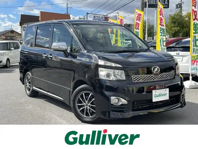 トヨタ ヴォクシー ZS 煌Ⅱ 長野県 2012(平24)年 15.6万km ブラック ワンオーナー/社外HDDナビ/・Bluetooth/CD/DVD/ワンセグTV/ビルトインETC/3列シート/ドライブレコーダー前方のみ/純正フロアマット/布系シート/両側パワースライドドア/社外16インチAW/キセノンオートライト/フォグランプ/Wエアバック/クルーズコントロール追従無し/パドルシフト/スマートキー/スペアキー1本/冷房WAC