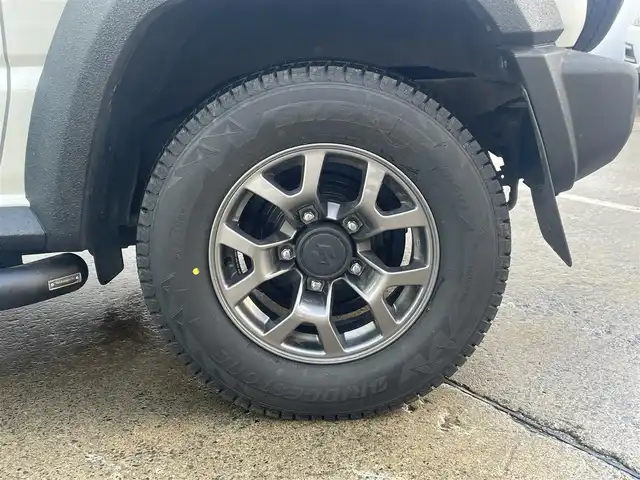 スズキ ジムニー シエラ JC 青森県 2024(令6)年 0.9万km ピュアホワイトP 寒冷地仕様/ワンオーナー/4WD/クリアランスソナー/純正15AW/純正フロアマット/フォグランプ/オートライト/前席シートヒーター/クルーズコントロール/アイドリングストップ/車線逸脱警報/衝突軽減システム/横滑り防止機能/ヒルスタートアシスト/盗難防止装置/UVカットガラス/プライバシーガラス/背面タイヤ/夏タイヤ積み込み有（AW無）/ETC2.0/スペアキー/純正スターター/保証書/取扱説明書/保証書