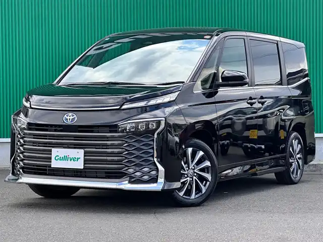 トヨタ ヴォクシー ハイブリッド S－Z 宮城県 2025(令7)年 0.1万km未満 アティチュードブラックマイカ ディスプレイオーディオプラス/・コネクティッドナビ対応10.5インチディスプレイ/・車載メモリーナビ/・CD/DVD/・地デジTV/・USB/HDMI/・AppleCarPlay/AndroidAuto/・ETC2.0/快適利便パッケージHigh/・ハンズフリーパワースライドドア/・パワーバックドア/・ナノイーX/・ステアリングヒーター/・シートヒーター（2列目左右）/・オットマン（2列目左右/・角度調整付きアームレスト（2列目左右）/トヨタチームメイト/・アドバンストパーク（リモート機能付）/・パーキングサポートブレーキ（周囲静止物/後方歩行者）/寒冷地仕様/＝＝＝/セーフティセンス/・プリクラッシュセーフティ/・レーントレーシングアシスト/・レーンディパーチャーアラート/・レーダークルーズコントロール/・オートマチックハイビーム/・ロードサインアシスト/・ドライバー異常時対応システム/・プロアクティブドライビングアシスト/・発進遅れ告知機能/アクセサリーコンセント（AC100V/1500W）/ハーフレザーシート/快適温熱シート（前席）/LEDヘッドランプ