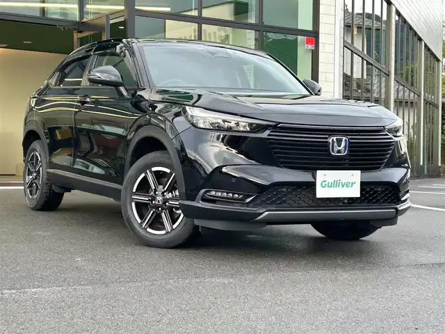 ホンダ ヴェゼル ハイブリッド e:HEV X 愛媛県 2022(令4)年 1.3万km クリスタルブラックパール 純正ナビ（Bluetooth/DVD）/ETC/前後ドライブレコーダー/バックカメラ/Honda SENSING/衝突軽減ブレーキ（CMBS）/誤発進抑制機能/歩行者事故低減ステアリング/路外逸脱抑制機能/渋滞追従機能付アダプティブクルーズコントロール（ACC）/車線維持支援システム（LKAS）/先行車発進お知らせ機能/標識認識機能/後方誤発進抑制機能/USB入力端子/純正16インチアルミホイール/純正フロアマット/ドアバイザー/LEDヘッドライト/オートマチックハイビーム/フォグランプ/プッシュスタート/スマートキー
