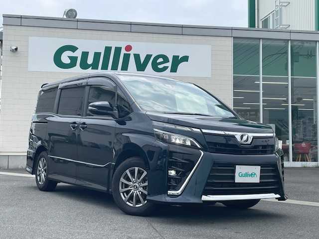トヨタ ヴォクシー ZS 静岡県 2018(平30)年 2.6万km ブラッキッシュアゲハガラスフレーク ●純正ナビ/(フルセグ/CD/DVD/Bluetooth)/(NSZT-W68T)/●バックカメラ/●クルーズコントロール/●衝突被害軽減システム/●レーンキープアシスト/●LEDライト＆フォグランプ/●オートライト/●オートマチックハイビーム/●革巻きステアリング/●ステアリングスイッチ/●ETC/●前方ドライブレコーダー/●社外15インチアルミホイール/(WALD　SPORTS)/●サマータイヤ4本付/(純正アルミホイール)/●両側パワースライド/●電動格納ウィンカーミラー/●純正フロアマット/●ドアバイザー/●スマートキー/●プッシュスタート/●W＋ニーSRS＋ABS/●保証書/●車両取扱説明書/●ナビ取扱説明書