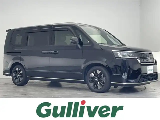 ホンダ ステップワゴン スパーダ eHEV 熊本県 2023(令5)年 0.9万km クリスタルブラックパール 純正8インチナビ/(Bluetooth/CD/DVD/USB/SD/フルセグTV)/ホンダセンシング/・衝突軽減ブレーキ（CMBS）/・誤発進抑制機能/・後方誤発進抑制機能/・近距離衝突軽減ブレーキ/・歩行者事故低減ステアリング/・路外逸脱抑制機能/・渋滞追従機能付アダプティブクルーズコントロール/・車線維持支援システム（LKAS）/・トラフィックジャムアシスト（渋滞運転支援機能）/・先行車発進お知らせ機能/・標識認識機能/・オートマチックハイビーム/・アダプティブドライビングビーム/バックカメラ/クリアランスソナー/ブラインドスポットインフォメーション/LEDヘッドライト/両側パワースライドドア/パワーバックドア/ハーフレザーシート/D/Nシートヒーター/二列目オットマン/電動パーキングブレーキ/オートブレーキホールド/パドルシフト/純正フロアマット/ドアバイザー/プッシュスタート/スマートキー/ステアリングリモコン