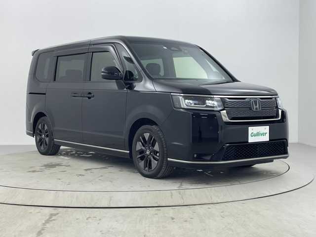 ホンダ ステップワゴン スパーダ eHEV 熊本県 2023(令5)年 0.9万km クリスタルブラックパール 純正8インチナビ/(Bluetooth/CD/DVD/USB/SD/フルセグTV)/ホンダセンシング/・衝突軽減ブレーキ（CMBS）/・誤発進抑制機能/・後方誤発進抑制機能/・近距離衝突軽減ブレーキ/・歩行者事故低減ステアリング/・路外逸脱抑制機能/・渋滞追従機能付アダプティブクルーズコントロール/・車線維持支援システム（LKAS）/・トラフィックジャムアシスト（渋滞運転支援機能）/・先行車発進お知らせ機能/・標識認識機能/・オートマチックハイビーム/・アダプティブドライビングビーム/バックカメラ/クリアランスソナー/ブラインドスポットインフォメーション/LEDヘッドライト/両側パワースライドドア/パワーバックドア/ハーフレザーシート/D/Nシートヒーター/二列目オットマン/電動パーキングブレーキ/オートブレーキホールド/パドルシフト/純正フロアマット/ドアバイザー/プッシュスタート/スマートキー/ステアリングリモコン