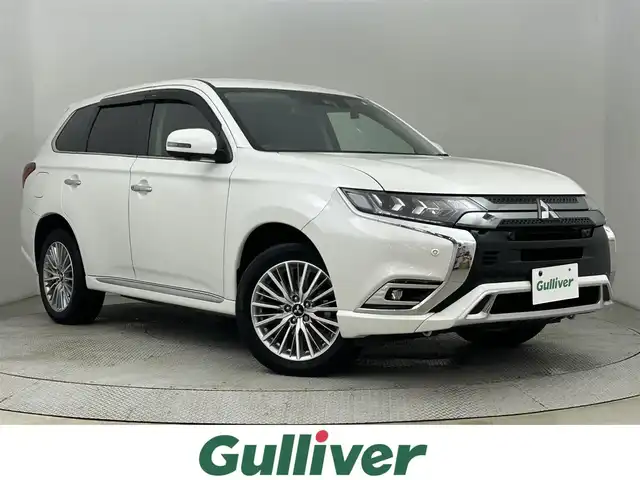 三菱 アウトランダー ＰＨＥＶ G 道央・札幌 2020(令2)年 2万km シルキーホワイト ・4WD/・寒冷地仕様/・純正SDナビ/・CD/DVD/SD/BT/フルセグ/・社外ETC/・前後ドライブレコーダー/・デジタルインナーミラー/・衝突軽減ブレーキ/・レーンキープアシスト/・アダプティブクルーズコントロール/・前後コーナーセンサー/・ブラインドスポットモニター/・横滑り防止/・オートマチックハイビーム/・LEDヘッドライト/・前席パワーシート/・前席シートヒーター/・ステアリングヒーター/・100V充電/・純正18インチAW/・純正フロアマット/・プッシュスタート/・スマートキー