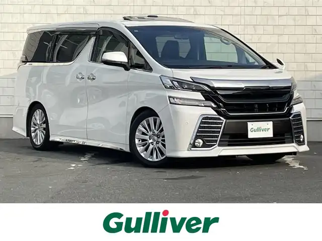 トヨタ ヴェルファイア Z Aエディション 愛知県 2015(平27)年 8.2万km ホワイトパールクリスタルシャイン TEIN車高調/モデリスタフロントグリル/ETC/USB/HDMI接続/クルーズコントロール/両側パワースライドドア/ツインムーンルーフ/純正フロアマット/ウォークスルー（2列目）/オットマン（N、2列目）/純正18インチアルミホイール/LEDヘッドライト/コーナーセンサー/横滑り防止装置/衝突軽減ブレーキ/MTモード付きAT/AC100V/全席オートエアコン/スマートキー/プッシュスタート