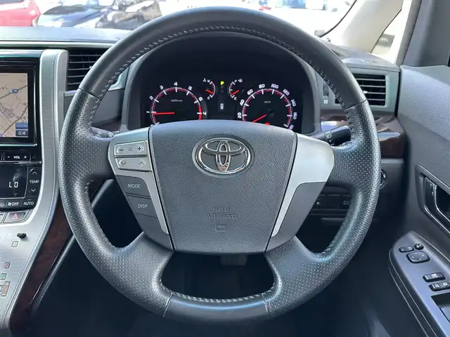 トヨタ ヴェルファイア 2．4Z 三重県 2013(平25)年 14.6万km ホワイトパールクリスタルシャイン 8インチナビ（Bluetooth/地デジTV/CD/DVD/AM/FM/SD）/バックカメラ/パワースライドドア（後席両側）/バックドアイージークローザー/ETC/スペアキー/左右独立温度調整オートエアコン/リアオートエアコン/ナノイー（フロント）/SRSエアバック（運転席/助手席/サイド/カーテン/ニー）/スモーク加飾付HIDヘッドランプ/メッキリング/オートライト/メッキ横桟フロントグリル/開口部台形フロントエアロバンパー/メッキリング付スポーツタイプフロントフォグランプ/サイドクラッディングパネル/リアスポイラー/リアエアロバンパー/スモークレンズLEDリアコンビネーションランプ/メッキバックドアガーニッシュ/マフラーカッター/235/50R18タイヤ/18インチアルミホイール/レッド指針スポーツタイプオプティトロンメーター（自発光式アナログメーター）/ディンプル革巻きステアリングホイール/ダークレッドトリコットシート/リラックスキャプテンシート/マニュアルオットマン/回転式アームレスト/スマートエントリー/スタートシステム/イモビライザー/ブラックエンジンスイッチ