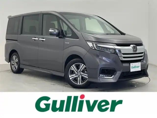 ホンダ ステップワゴン スパーダ ハイブリッド G ホンダセンシング 富山県 2019(平31)年 2.7万km モダンスティールM 社外ナビ（AM/FM/CD/BT/USB/SD）/バックカメラ/前後ドライブレコーダー/両側パワースライドドア/レーダークルーズコントロール/衝突軽減ブレーキ/レーンキープアシスト/スマートキー/スペアキー有/プッシュスタート/LEDヘッドライト/オートライト/ビルトインETC/電動パーキングブレーキ/オートブレーキホールド/横滑り防止装置/革巻きステアリング/純正フロアマット/保証書/取扱説明書