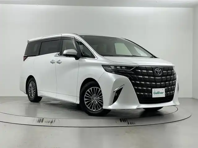 トヨタ アルファードハイブリット エグゼクティブ ラウンジ 埼玉県 2024(令6)年 1.8万km プラチナホワイトパールマイカ トヨタチームメイト/トヨタセーフティセンス/ブラインドスポットモニター/安全降車アシスト/車両接近通報装置/左右独ムーンルーフ/１４インチリアエンターテインメントシステム/純正ナビゲーション/（フルセグTV/CD/DVD/Bluetooth/ミラキャスト/HDMI/USB/AM/FM）/JBLプレミアムサウンドシステム（１５スピーカー）/全方位カメラ/エグゼクティブラウンジシート/リフレッシュシート/リアマルチオペレーションパネル（脱着式）/読書灯/アクティブノイズコントロール/アドバンスドパーク（リモート機能付き）/デジタルインナーミラー/ベージュシート/両側パワースライドドア /前後ドライブレコーダー/社外アルミスタッドレスタイヤ車載