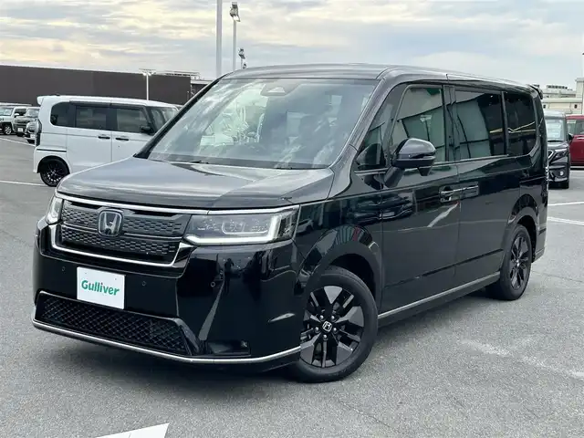 ホンダ ステップワゴン スパーダ eHEV 奈良県 2023(令5)年 2.8万km クリスタルブラックパール ワンオーナー/Gathers11.4インチナビ(フルセグTV/CD/DVD/AM・FM/BT/HDMI)/ETC/Honda　SENSING/バックカメラ/両側パワースライドドア/パドルシフト/シートヒーター(D/N席)/2列目キャプテンシート/オットマン/パワーテールゲート/純正16インチアルミホイール(ベルリナブラック＋ダーク切削クリア)/LEDヘッドライト(シーケンシャルウインカー)/フォグランプ/LEDアクティブコーナリングライト/全席USBチャージャー(Type-C)/本革ステアリングホイール/無限フロアマット/スペアキー/保証書/取扱説明書