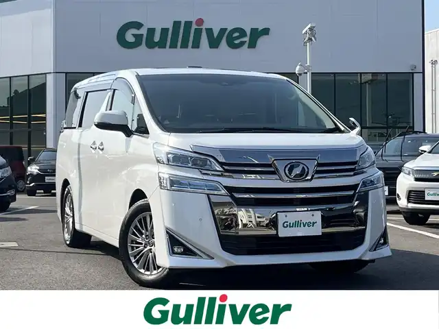 トヨタ ヴェルファイア V 愛媛県 2019(令1)年 5.3万km ホワイトパールクリスタルシャイン 禁煙車/登録時走行距離：52224km/ディーラーオプション純正10インチナビ/CD/DVD/フルセグTV/Bluetooth/バックカメラ/３６０°ドライブレコーダー/デジタルインナーミラー/ビルトインETC/純正12.1インチフリップダウンモニター(リモコン有)/サンルーフ/衝突被害軽減システム/クリアランスソナー/横滑り防止装置/レーンキープアシスト/レーダークルーズコントロール/LEDヘッドライト/フォグランプ/オートライト/オートマチックハイビーム/レザーシート/運転席パワーシート/オットマン/両側パワースライドドア/エンジンスタートボタン/スマートキー/純正フロアマット/純正１７インチアルミホイール