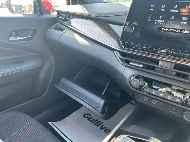 日産 オーラ ニスモ 栃木県 2022(令4)年 1.6万km ピュアホワイトパール 全方位運転支援システム/・インテリジェントエマージェンシーブレーキ/・踏み間違い衝突防止アシスト　・標識検知機能/・前方衝突予測警報　・ふらつき警報　・後退時車両検知機能/・車線逸脱警報　・車線逸脱防止支援システム/・後側方衝突防止支援システム/車両検知警報/9インチワイドディスプレイコネクトナビゲーションシステム/フルセグTV/Bluetooth/USB/AppleCarPlay/インテリジェントアラウンドビューモニター/インテリジェントルームミラー/ETC2.0/ドライブレコーダー/ワイヤレス充電/ブラックフードデカール/NISMOロゴ入りレッド加飾付ブラック合皮ハーフレザーシート/スマートキー/プッシュEgスタート/純正17インチAW/アダプティブLEDヘッドライト/フォグランプ