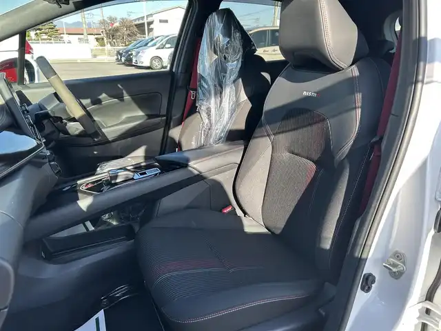 日産 オーラ ニスモ 栃木県 2022(令4)年 1.6万km ピュアホワイトパール 全方位運転支援システム/・インテリジェントエマージェンシーブレーキ/・踏み間違い衝突防止アシスト　・標識検知機能/・前方衝突予測警報　・ふらつき警報　・後退時車両検知機能/・車線逸脱警報　・車線逸脱防止支援システム/・後側方衝突防止支援システム/車両検知警報/9インチワイドディスプレイコネクトナビゲーションシステム/フルセグTV/Bluetooth/USB/AppleCarPlay/インテリジェントアラウンドビューモニター/インテリジェントルームミラー/ETC2.0/ドライブレコーダー/ワイヤレス充電/ブラックフードデカール/NISMOロゴ入りレッド加飾付ブラック合皮ハーフレザーシート/スマートキー/プッシュEgスタート/純正17インチAW/アダプティブLEDヘッドライト/フォグランプ