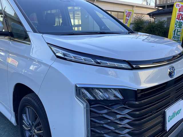 トヨタ ヴォクシー ハイブリッド S－Z 埼玉県 2023(令5)年 1.5万km ホワイトパールクリスタルシャイン Toyota Safety Sense/純正メモリナビ/　　Bluetooth/CD/DVD/ブルーレイ/フルセグ/HDMI/純正フリップダウンモニター/パノラミックビューモニター/両側パワースライドドア/パワーバックドア/レーダークルーズコントロール/LEDオートヘッドライト、オートマチックハイビーム/ハーフレザーシート/全席シートヒーター/純正16インチアルミホイール/パーキングアシスト/USBポート/100V充電/横滑り防止装置/ETC2.0/禁煙車/保証書/取扱説明書/スペアキー