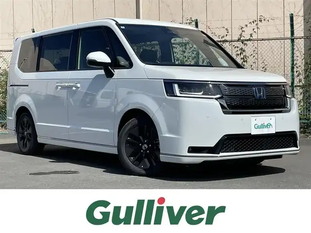ホンダ ステップワゴン スパーダ eHEV 東京都 2025(令7)年 0.1千km パール 登録済未使用車　/純正１１型メモリナビ＆フルセグ　/・BluetoothAudio/USB/CD/DVD/・AppleCarPlay＆AndroidAuto/両側パワースライドア　/パワーバックドア/ＬＥＤヘッドランプ　　/ハーフレザーシート/・前席シートヒーター　/・オットマンシート/ブラインドスポットモニター/ホンダセンシング/・アダプティブクルーズコントロール/・オートハイビーム /・追従軽減ブレーキ/・後方誤発進抑制機能/・歩行者事故低減ステアリング/・車線維持支援システム/・路外逸脱抑制機能/プッシュエンジンスタート/スペアキーX１/保証書＆取説