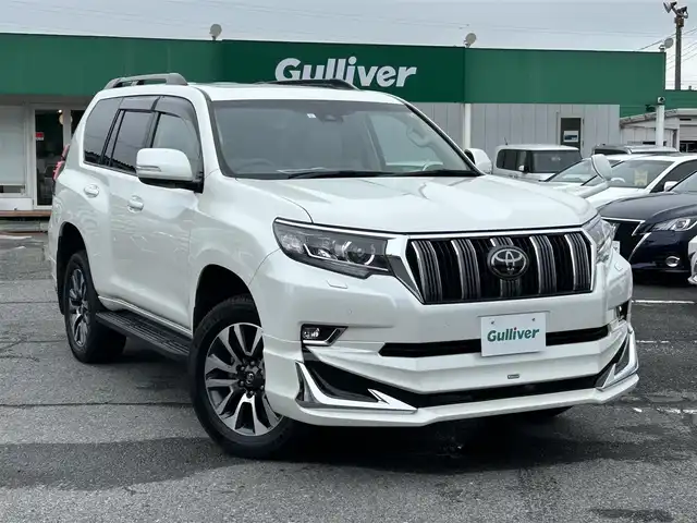 トヨタ ランドクルーザー プラド TX Lパッケージ 千葉県 2023(令5)年 1.5万km ホワイトパールクリスタルシャイン モデリスタエアロ【F/R/Rウイング】/サンルーフ/ベージュレザーシート/純正9インチSDナビ【NSZT-Y68T】/・CD/DVD/MSV/Bluetooth/フルセグ/バックカメラ/前席パワーシート/前席シートヒーター/前席シートベンチレーション/トヨタセーフティーセンス/・プリクラッシュセーフティー/・レーンディパーチャーアラート/・オートマチックハイビーム/・ロードサインアシスト/・アダプティブクルーズコントロール/スマートキー/コーナーセンサー/電動格納サードシート/純正19インチアルミホイール/ETC/純正LEDヘッドライト/フォグランプ/本革巻きステアリング/木目調パネル/ルーフレール/サイド＆カーテンエアバッグ/新車時保証書＆取扱説明書