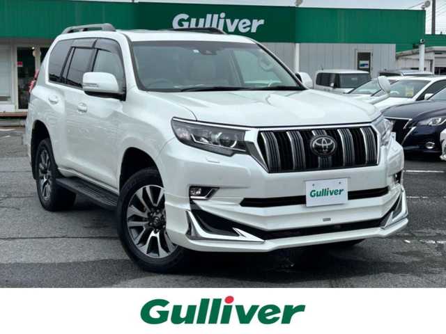 トヨタ ランドクルーザー プラド TX Lパッケージ 千葉県 2023(令5)年 1.5万km ホワイトパールクリスタルシャイン モデリスタエアロ【F/R/Rウイング】/サンルーフ/ベージュレザーシート/純正9インチSDナビ【NSZT-Y68T】/・CD/DVD/MSV/Bluetooth/フルセグ/バックカメラ/前席パワーシート/前席シートヒーター/前席シートベンチレーション/トヨタセーフティーセンス/・プリクラッシュセーフティー/・レーンディパーチャーアラート/・オートマチックハイビーム/・ロードサインアシスト/・アダプティブクルーズコントロール/スマートキー/コーナーセンサー/電動格納サードシート/純正19インチアルミホイール/ETC/純正LEDヘッドライト/フォグランプ/本革巻きステアリング/木目調パネル/ルーフレール/サイド＆カーテンエアバッグ/新車時保証書＆取扱説明書