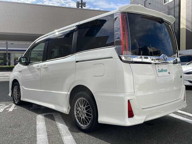 トヨタ ノア ハイブリッド Si 広島県 2017(平29)年 3.5万km ホワイトパールクリスタルシャイン 純正9インチナビ/(フルセグTV/CD/DVD/BT/AM/FM)/フリップダウンモニター/バックカメラ/衝突被害軽減システム/車線逸脱警報/クルーズコントロール/横滑り防止装置/ETC/アイドリングストップ/LEDヘッドライト/フォグランプ/オートライト/ウィンカーミラー/電動格納ミラー/純正１６インチAW/シートヒーター/シートリフター/プッシュスタート/スマートキー/フロアマット/ドアバイザー/スペアキー/取扱説明書/保証書