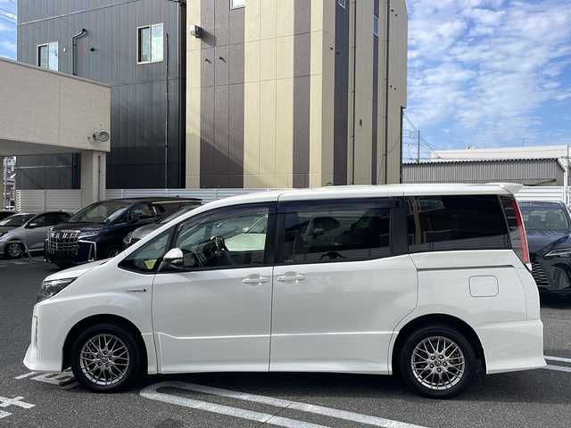 トヨタ ノア ハイブリッド Si 広島県 2017(平29)年 3.5万km ホワイトパールクリスタルシャイン 純正9インチナビ/(フルセグTV/CD/DVD/BT/AM/FM)/フリップダウンモニター/バックカメラ/衝突被害軽減システム/車線逸脱警報/クルーズコントロール/横滑り防止装置/ETC/アイドリングストップ/LEDヘッドライト/フォグランプ/オートライト/ウィンカーミラー/電動格納ミラー/純正１６インチAW/シートヒーター/シートリフター/プッシュスタート/スマートキー/フロアマット/ドアバイザー/スペアキー/取扱説明書/保証書