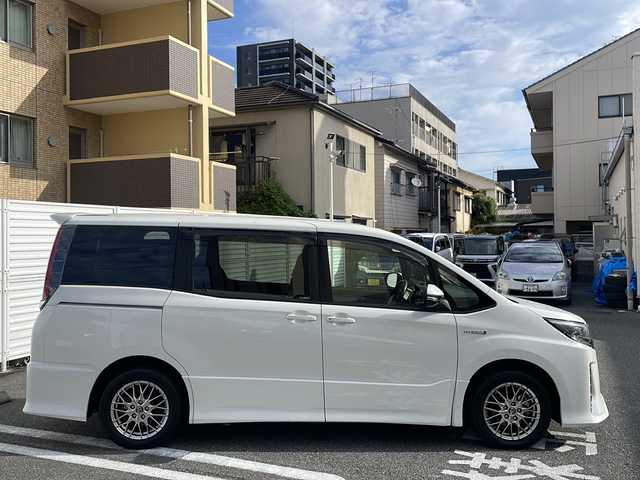 トヨタ ノア ハイブリッド Si 広島県 2017(平29)年 3.5万km ホワイトパールクリスタルシャイン 純正9インチナビ/(フルセグTV/CD/DVD/BT/AM/FM)/フリップダウンモニター/バックカメラ/衝突被害軽減システム/車線逸脱警報/クルーズコントロール/横滑り防止装置/ETC/アイドリングストップ/LEDヘッドライト/フォグランプ/オートライト/ウィンカーミラー/電動格納ミラー/純正１６インチAW/シートヒーター/シートリフター/プッシュスタート/スマートキー/フロアマット/ドアバイザー/スペアキー/取扱説明書/保証書