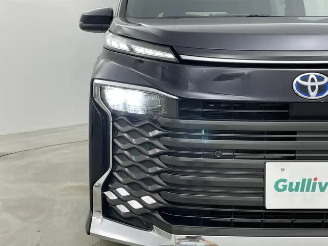 トヨタ ヴォクシー ハイブリッド S－Z 岡山県 2023(令5)年 3万km スパークリングブラックパールクリスタルシャイン 純正１０．５インチディスプレイオーディオナビ/（CD/DVD/BT/フルセグ/Carplay/AndroidAuto/HDMI)/ワンオーナー/快適利便パッケージ/(ハンズフリーデュアルパワースライドドア/パワーバックドア/ナノイーX/ステアリングヒーター/オットマン）/レーダークルーズコントロール/１００Ｖ電源　/ビルトインＥＴＣ２．０/両側電動スライドドア/バックカメラ/衝突軽減ブレーキ/レーンキープアシスト/踏み間違い防止/オートブレーキホールド/ハーフレザーシート/シートヒーター/オートLEDヘッドライト/オートハイビーム/フォグランプ/コーナーセンサー（前/後）/ドライブレコーダー（前/後）/純正17インチAW/純正フロアマット/オートブレーキホールド/禁煙車/スマートキー×1