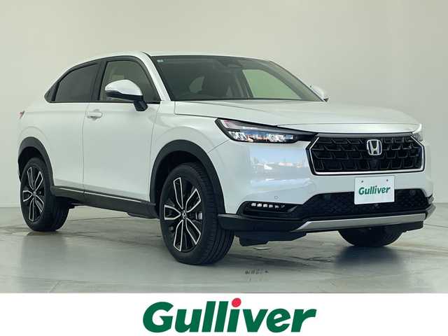 ホンダ ヴェゼル ハイブリッド e:HEV Z 愛知県 2025(令7)年 0.1千km パール 登録済未使用車　5km/ホンダコネクトディスプレイ/・ナビゲーション機能/・フルセグテレビ/・Bluetooth/バックカメラ/ETC2.0/ワイヤレス充電器/ステアリングスイッチ/ベルリナブラックフロントグリル/ハンズフリーアクセスパワーテールゲート/LEDシーケンシャルターンシグナルランプ/ブラインドスポットインフォメーション/後退出庫サポート/ホンダセンシング/・衝突軽減ブレーキ/・先行車発信お知らせ機能/・歩行者事故低減システム/・路外逸脱抑制機能/・標識認識機能/・渋滞追従機能アダプティブクルーズコントロール/・車線維持支援システム/・トラフィックジャムアシスト/・誤発信誤後退抑制機能/・アダプティブドライビングビーム/・近距離衝突軽減ブレーキ/・急アクセル抑制機能/ステアリングヒーター/シートヒーター/ドライブモードセレクター