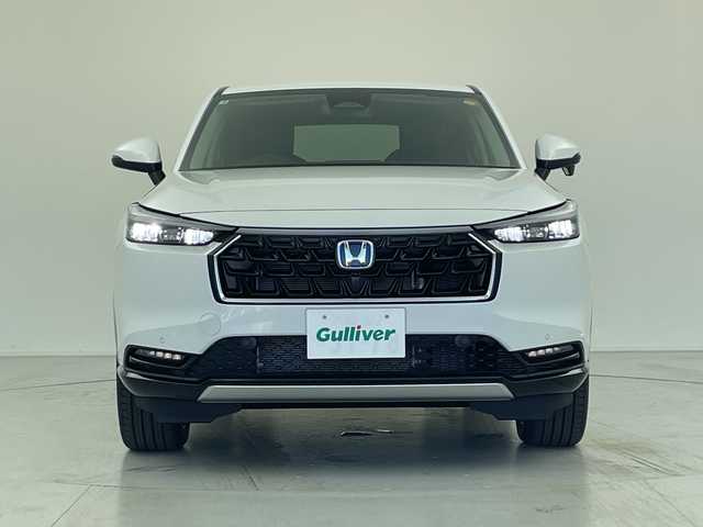 ホンダ ヴェゼル ハイブリッド e:HEV Z 愛知県 2025(令7)年 0.1千km パール 登録済未使用車　5km/ホンダコネクトディスプレイ/・ナビゲーション機能/・フルセグテレビ/・Bluetooth/バックカメラ/ETC2.0/ワイヤレス充電器/ステアリングスイッチ/ベルリナブラックフロントグリル/ハンズフリーアクセスパワーテールゲート/LEDシーケンシャルターンシグナルランプ/ブラインドスポットインフォメーション/後退出庫サポート/ホンダセンシング/・衝突軽減ブレーキ/・先行車発信お知らせ機能/・歩行者事故低減システム/・路外逸脱抑制機能/・標識認識機能/・渋滞追従機能アダプティブクルーズコントロール/・車線維持支援システム/・トラフィックジャムアシスト/・誤発信誤後退抑制機能/・アダプティブドライビングビーム/・近距離衝突軽減ブレーキ/・急アクセル抑制機能/ステアリングヒーター/シートヒーター/ドライブモードセレクター