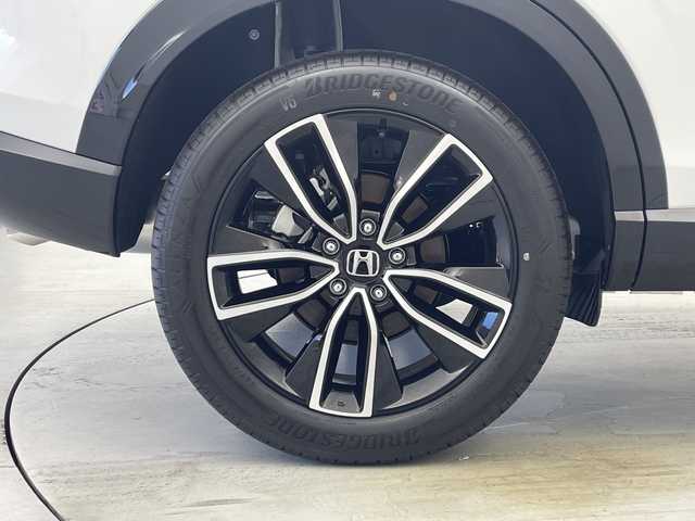 ホンダ ヴェゼル ハイブリッド e:HEV Z 愛知県 2025(令7)年 0.1千km パール 登録済未使用車　5km/ホンダコネクトディスプレイ/・ナビゲーション機能/・フルセグテレビ/・Bluetooth/バックカメラ/ETC2.0/ワイヤレス充電器/ステアリングスイッチ/ベルリナブラックフロントグリル/ハンズフリーアクセスパワーテールゲート/LEDシーケンシャルターンシグナルランプ/ブラインドスポットインフォメーション/後退出庫サポート/ホンダセンシング/・衝突軽減ブレーキ/・先行車発信お知らせ機能/・歩行者事故低減システム/・路外逸脱抑制機能/・標識認識機能/・渋滞追従機能アダプティブクルーズコントロール/・車線維持支援システム/・トラフィックジャムアシスト/・誤発信誤後退抑制機能/・アダプティブドライビングビーム/・近距離衝突軽減ブレーキ/・急アクセル抑制機能/ステアリングヒーター/シートヒーター/ドライブモードセレクター