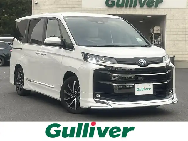 トヨタ ノア ハイブリッド S－Z 島根県 2025(令7)年 0.7万km ホワイトパールクリスタルシャイン モデリスタエアロ/フリップダウンモニター/純正１０型ＳＤナビ　/フルセグTV　/ＤＶＤ再生　/Ｂｌｕｅｔｏｏｔｈ接続　/両側パワースライドドア　/バックカメラ　/ビルトインＥＴＣ2.0/前後ドライブレーダー/レーダークルーズコントロール/衝突軽減ブレーキ/ヘッドアップディスプレイ/パワーバックドア　/前後コーナーセンサー/前席・２列目シートヒーター　/ホワイトレザー調シートカバー/ステアリングヒーター/オートハイビーム／ライト/スマートキー／プッシュスタート/純正LEDヘッドライト/純正１７インチアルミホイール/保証書/取扱説明書/スペアキー1本