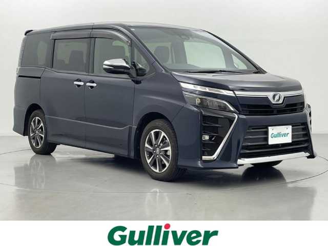 トヨタ ヴォクシー ZS 煌 熊本県 2018(平30)年 7万km ブラッキッシュアゲハガラスフレーク 純正10インチナビ（ＣＤ・ＤＶＤ・フルセグ・ＢＴ・ＳＤ・HDMI）/純正フリップダウンモニター/バックカメラ　/社外前後ドライブレコーダー　/ビルトインＥＴＣ　/両側パワースライドドア　/トヨタセーフティーセンス/・プリクラッシュセーフティ/・先行車発進お知らせ機能/・レーンキープアシスト/・クルーズコントロール/・レーンディパーチャーアラート/・オートマチックハイビーム/横滑り防止/アイドリングストップ/純正フロアマット/純正１６インチAW/オートライト/LEDヘッドライト/フォグライト/スマートキー/プッシュスタート