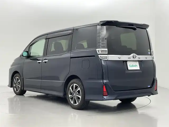 トヨタ ヴォクシー ZS 煌 熊本県 2018(平30)年 7万km ブラッキッシュアゲハガラスフレーク 純正10インチナビ（ＣＤ・ＤＶＤ・フルセグ・ＢＴ・ＳＤ・HDMI）/純正フリップダウンモニター/バックカメラ　/社外前後ドライブレコーダー　/ビルトインＥＴＣ　/両側パワースライドドア　/トヨタセーフティーセンス/・プリクラッシュセーフティ/・先行車発進お知らせ機能/・レーンキープアシスト/・クルーズコントロール/・レーンディパーチャーアラート/・オートマチックハイビーム/横滑り防止/アイドリングストップ/純正フロアマット/純正１６インチAW/オートライト/LEDヘッドライト/フォグライト/スマートキー/プッシュスタート