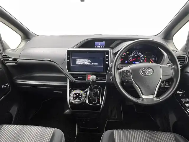 トヨタ ヴォクシー ZS 煌 熊本県 2018(平30)年 7万km ブラッキッシュアゲハガラスフレーク 純正10インチナビ（ＣＤ・ＤＶＤ・フルセグ・ＢＴ・ＳＤ・HDMI）/純正フリップダウンモニター/バックカメラ　/社外前後ドライブレコーダー　/ビルトインＥＴＣ　/両側パワースライドドア　/トヨタセーフティーセンス/・プリクラッシュセーフティ/・先行車発進お知らせ機能/・レーンキープアシスト/・クルーズコントロール/・レーンディパーチャーアラート/・オートマチックハイビーム/横滑り防止/アイドリングストップ/純正フロアマット/純正１６インチAW/オートライト/LEDヘッドライト/フォグライト/スマートキー/プッシュスタート