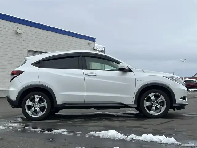 ホンダ ヴェゼル ハイブリッド X Lパッケージ 道北・旭川 2015(平27)年 11.4万km ホワイトオーキッドパール (株)IDOMが運営する【じしゃロン旭川店】の自社ローン対象車両になります。こちらは現金ご利用時の価格です。/自社ローンご希望の方は別途その旨お申付け下さい/ /・純正ナビ（SD）/・バックカメラ/・ETC/・クルーズコントロール/・パドルシフト/・両席シートヒーター/・ワイパーデアイサー/・プッシュスタート/・スマートキー1個/・オートライト/・フォグランプ・電動格納ミラー/・現車装着サマータイヤ 純正AW215/55R17