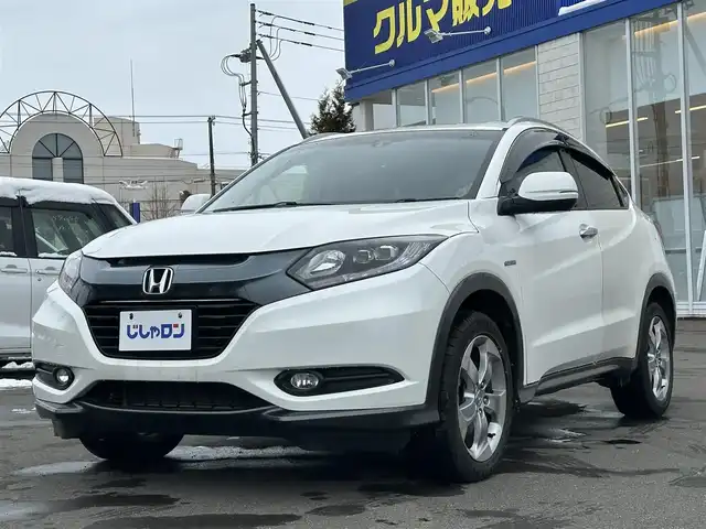 ホンダ ヴェゼル ハイブリッド X Lパッケージ 道北・旭川 2015(平27)年 11.4万km ホワイトオーキッドパール (株)IDOMが運営する【じしゃロン旭川店】の自社ローン対象車両になります。こちらは現金ご利用時の価格です。/自社ローンご希望の方は別途その旨お申付け下さい/ /・純正ナビ（SD）/・バックカメラ/・ETC/・クルーズコントロール/・パドルシフト/・両席シートヒーター/・ワイパーデアイサー/・プッシュスタート/・スマートキー1個/・オートライト/・フォグランプ・電動格納ミラー/・現車装着サマータイヤ 純正AW215/55R17