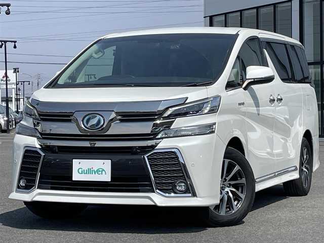 トヨタ ヴェルファイア ハイブリット ZR Gエディション 道央・札幌 2015(平27)年 7.2万km ホワイトパールクリスタルシャイン ４WD/寒冷地仕様/JBLプレミアムサウンドシステム/純正ディーラーOPナビ/CD/DVD/BT/フルセグ/純正フリップダウンモニター/プリクラッシュセーフティ/横滑り防止装置/レーダークルーズコントロール/クリアランスソナー/アラウンドビューモニター/ビルトインETC/ドライブレコーダー/EVMODE/ECOMODE/自動防眩ミラー/両側パワースライドドア/パワーバックドア/前席/２列目パワーシート/前席シートヒーター/D席メモリーシート/N席/２列目オットマン/レザーシート/革巻きステアリング/ステアリングリモコン/ハンドルヒーター/AC100V/電動パーキング/ブレーキホールド/レーダー探知機/MTモード付AT/プッシュスタート/スマートキー/LEDヘッドライト/オートライト/オートハイビーム/フォグランプ/電動格納ミラー/ウィンカーミラー/純正ラバーフロアマット/スペアキー