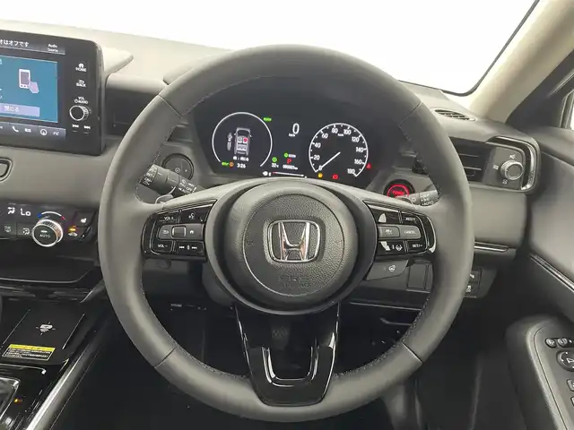 ホンダ ヴェゼル ハイブリッド e:HEV Z 熊本県 2025(令7)年 0.1万km未満 クリスタルブラックパール 登録済未使用車　/純正ナビ（ＡｐｐｌＣａｒＰｌａｙ・ＡｎｄｒｏｉｄＡｕｔｏ・フルセグ・ＢＴ・ＵＳＢ）/バックカメラ　/ビルトインETC2.0/前席シートヒーター　/前後クリアランスソナー　/アイドリングストップ　/横滑り防止/ダウンヒルアシスト/ホンダセンシング/・衝突軽減ブレーキ/・誤発進抑制機能/・後方誤発進抑制機能/・近距離衝突軽減ブレーキ/・歩行者事故低減ステアリング/・路外逸脱制御機能/・アダブティブクルーズコントロール/・渋滞運転支援機能/・先行車発進お知らせ/・標識認識システム/・ブラインドスポットモニター/・車線維持支援システム/・オートハイビーム/パワーバックドア/ステアリングヒーター/置くだけ充電/ハーフレザーシート/純正１８インチAW/オートライト/LEDヘッドライト/スマートキー/プッシュスタート/スペアキー1本/保証書/取扱説明書