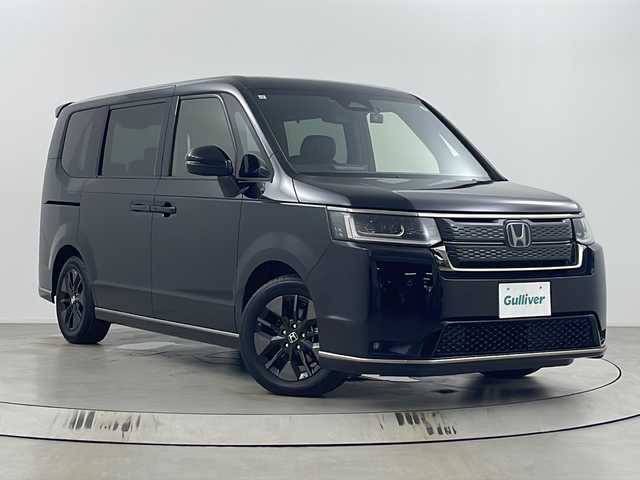 ホンダ ステップワゴン スパーダ eHEV 埼玉県 2024(令6)年 0.6万km クリスタルブラックパール 純正ナビ(LXM-247VFLi)/（CD・DVD・フルセグTV・Bluetooth・USB）/バックカメラ/前方ドライブレコーダー/ビルトインETC/両側パワースライドドア/前席シートヒーター/アダプティブクルーズコントロール/ブラインドスポットモニター/コーナーセンサー/レーンキープアシスト/横滑り防止装置/盗難防止装置/衝突軽減ブレーキ/先行車発進お知らせ機能/プリクラッシュセーフティ/ステアリングリモコン/パドルシフト/プッシュスタート/ブレーキホールド/オットマン/ロールサンシェード/純正フロアマット/電動リアゲート/フォグ/LEDヘッドライト/ウィンカーミラー/純正アルミホイール