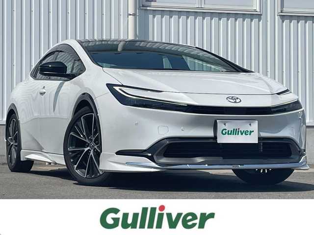 トヨタ プリウス Z 愛媛県 2024(令6)年 0.8万km プラチナホワイトパールマイカ 純正12.3インチディスプレイオーディオ/フルセグTV/Bluetooth　/全方位カメラ　/モデリスタエアロ/トヨタセーフティセンス/プリクラッシュセーフティ/レーダークルーズコントロール　/アドバンストパーク/緊急時操舵支援/車線逸脱防止装置/ブラインドスポットモニター/デジタルインナーミラー/D席シートメモリー機能/D/N席シートヒーター/シートベンチレーション　/ステアリングヒーター/パノラマルーフ　/電動トランクリッド　/純正ドライブレコーダー　/100Ｖ充電　/ワイヤレス充電　/ETC2.0/現状サマー(純正AW)(195/50/R19)/BRIDGESTONE ECOPIA
