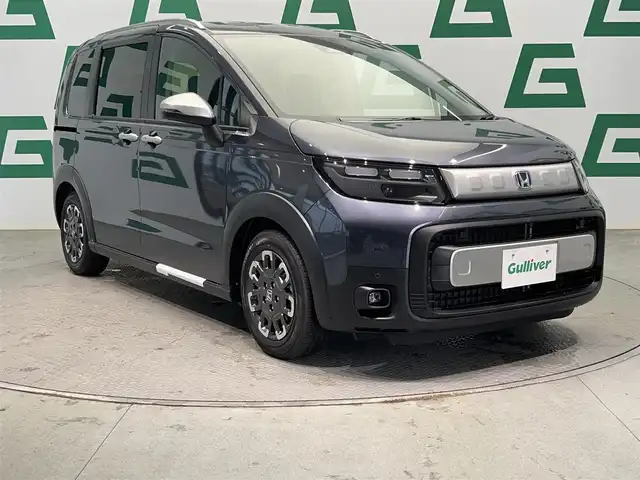 ホンダ フリード ハイブリット e:HEV クロスター 鹿児島県 2025(令7)年 0.1万km未満 メテオロイドグレーメタリック 登録済未使用車/禁煙/純正9インチナビ　（LXM-242ZFNI）/バックカメラ/両側パワースライドドア/ホンダセンシング/アダプティブクルーズコントロール/レーンキープアシスト/トラフィックジャムアシスト/前後コーナーセンサー/革巻きステアリング/電動パーキングブレーキ/オートブレーキホールド/シートヒーター
