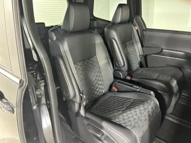 トヨタ ヴォクシー ハイブリッド S－Z 神奈川県 2024(令6)年 0.4万km アティチュードブラックマイカ 純正10.5型ディスプレイオーディオ/AM FM フルセグ Bluetooth CD DVD HDMI/バックカメラ/純正14型有機ELフリップダウンモニター/両側パワースライドドア/快適利便パッケージHigh/パワーバックドア/ステアリングヒーター/シートヒーター【1列目、2列目】/オットマン/角度調整付アームレスト/レーダークルーズコントロール/セーフティセンス/プリクラッシュセーフティ/レーントレーシングアシスト/レーンディパーチャーアラート/ロードサインアシスト/ドライバー異常時対応システム/プロアクティブドライビングアシスト/発進遅れ告知機能/フロントクロストラフィックアラート/レーンチェンジアシスト/パーキングサポートブレーキ/ブラインドスポットモニター/アドバンスドライブ/クリアランスソナー/ステアリングリモコン/ハーフレザーシート/ビルトインETC2.0/オートホールド/LEDヘッドライト/オートライト/オートマチックハイビーム/スマートキー/スペアキー/純正17インチアルミホイル