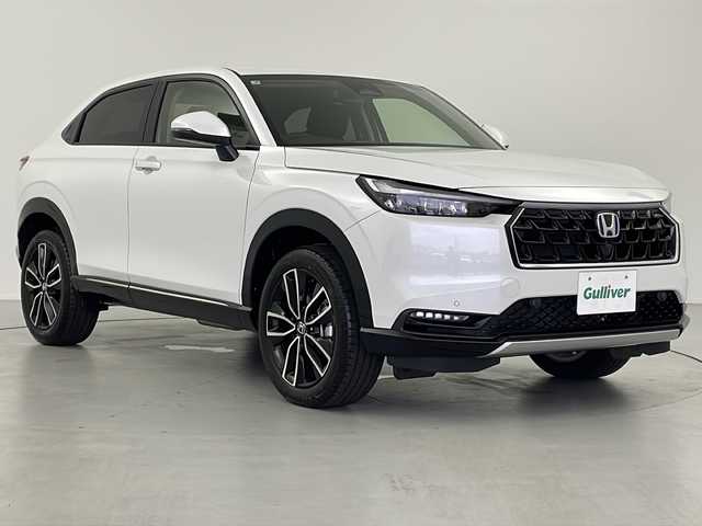 ホンダ ヴェゼル ハイブリッド e:HEV Z 岐阜県 2025(令7)年 0.1万km未満 プラチナホワイトパール Honda CONNECT 9インチディスプレーオーディオ/・ETC2.0車載器+ワイヤレス置くだけ充電器 (220000円)　/・Apple CarPlay/・Android Auto/・Bluetooth/・AM/FM/・USB/・車内WI-FI/フロントグリル　ベルリナブラック (41250円)/革巻きステアリング/・ハンドルヒーター/・ステアリングリモコン/・パドルシフト/スペアキー有/追従型クルーズコントロール/レーンキープアシスト/前後クリアランスソナー/電動パワーバックドア/ハーフレザーシート/・シートヒーター(D席/N席)/衝突軽減ブレーキ/・オートブレーキホールド/LEDヘッドライト/・オートライト/ダウンヒルアシストコントロール