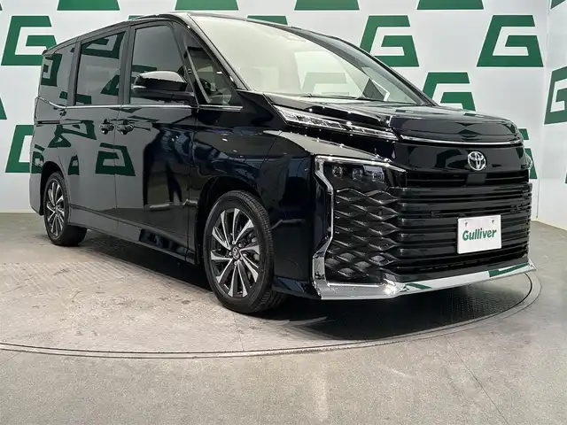 トヨタ ヴォクシー S－Z 鹿児島県 2025(令7)年 0.1万km未満 グリッターブラックガラスフレーク 純正10.5インチナビ機能付きディスプレイオーディオ/（CD/DVD/Bluetooth/フルセグＴＶ/HDMI）/両側パワースライドドア/トヨタセーフティセンス/純正ETC2.0/前席シートヒーター/レーダークルーズコントロール/プロジェクター式LEDヘッドランプ（メーカーＯＰ）/ディスプレイオーディオPlus（メーカーＯＰ）/電動パーキングブレーキ/オートブレーキホールド